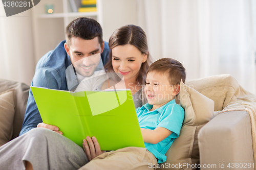 Image of happy family reading book at home