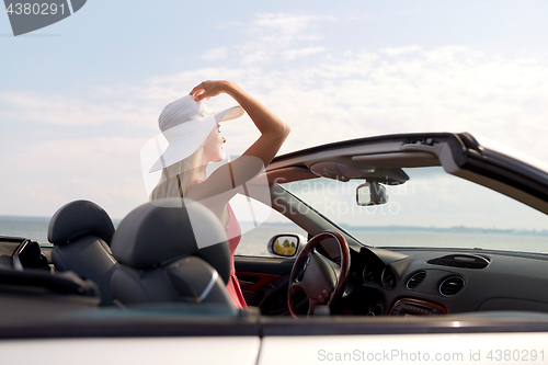 Image of happy young woman in convertible car