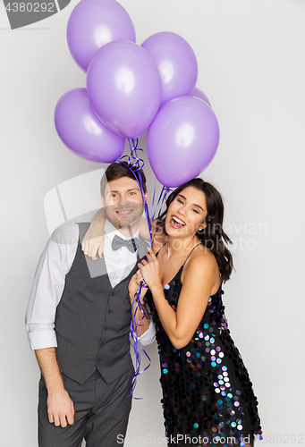 Image of happy couple with ultra violet balloons at party