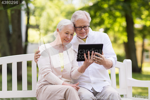 Image of happy senior couple with tablet pc at summer park