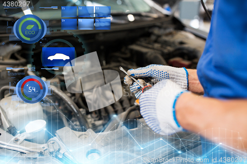 Image of mechanic man with wrench repairing car at workshop