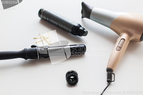 Image of hairdryer, styler or curling iron and hair spray