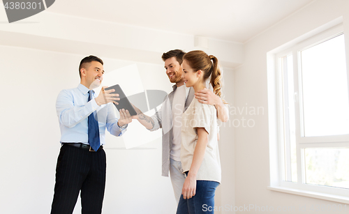 Image of couple and realtor with tablet pc at new home