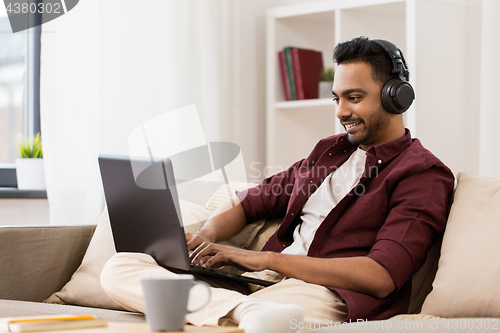 Image of man in headphones with laptop listening to music