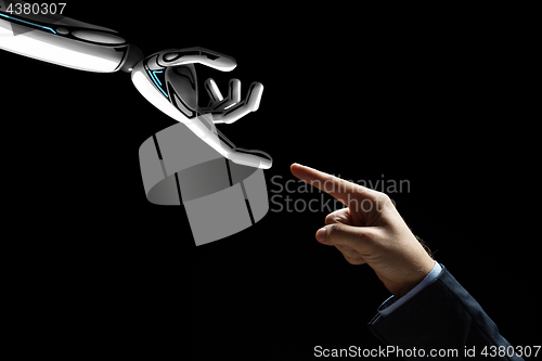 Image of robot and human hand connecting fingers