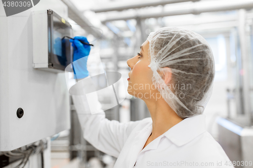 Image of woman programming computer at ice cream factory