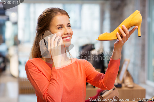 Image of young woman calling on smartphone at shoe store