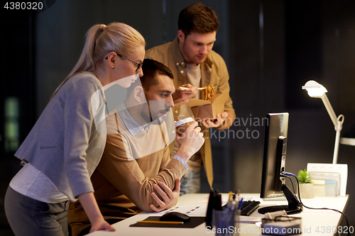 Image of business team with computer working late at office