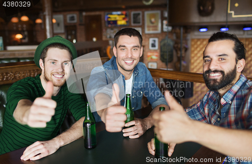 Image of happy male friends drinking beer at bar or pub