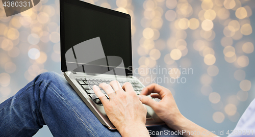 Image of close up of man typing on laptop keyboard