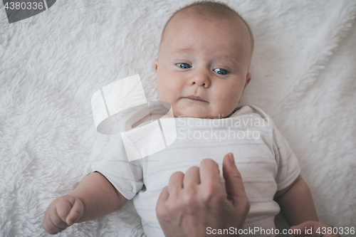 Image of mom dresses the baby on the bed