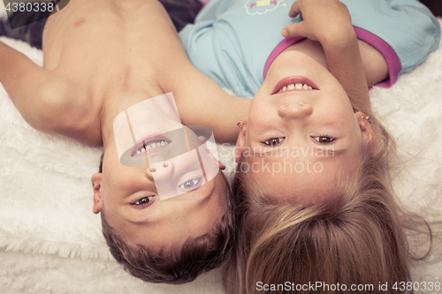 Image of Lovely brother and sister lying in bed at home. 