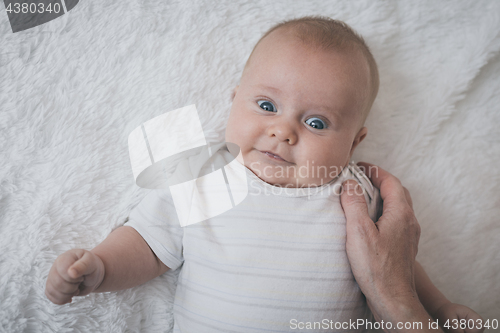 Image of mom dresses the baby on the bed 