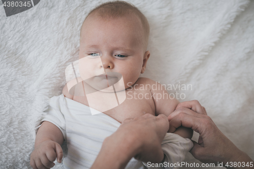 Image of mom dresses the baby on the bed