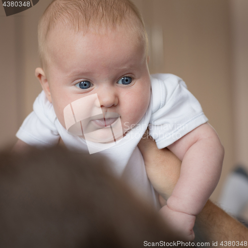 Image of Father and baby son  playing on the bed.