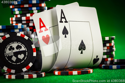 Image of Stack of chips and two aces on the table on the green baize