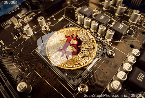 Image of Gold Bit Coin BTC coins on the motherboard. Bitcoin is a worldwi