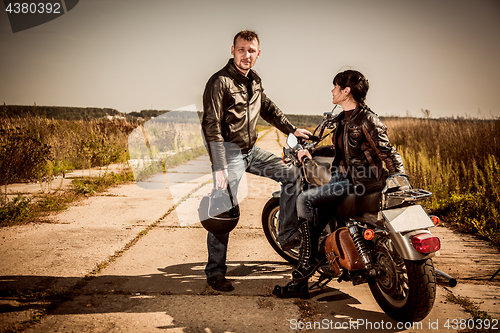 Image of Bikers couple Man and woman near a motorcycle on the road