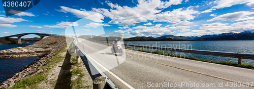 Image of Biker rides a road with Atlantic Ocean Road in Norway.