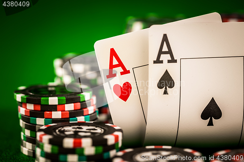 Image of Stack of chips and two aces on the table on the green baize