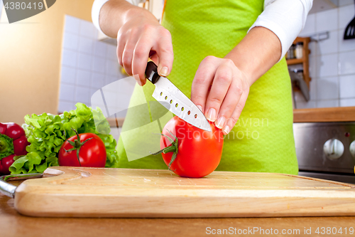 Image of Woman\'s hands cutting tomato