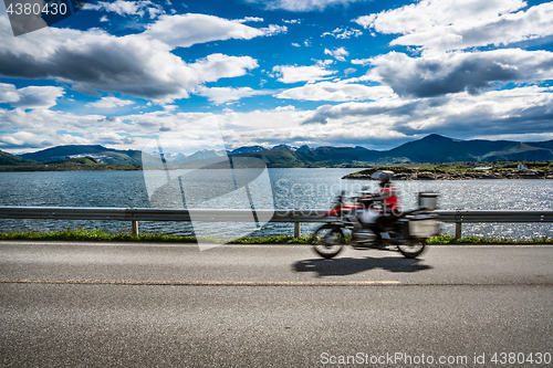 Image of Biker rides a road with Atlantic Ocean Road in Norway.