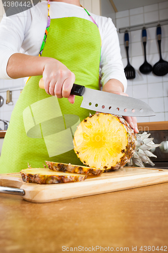 Image of Woman\'s hands cutting pineapple