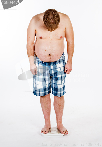 Image of Overweight, fat man and scales.