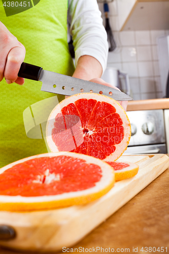Image of Woman\'s hands cutting grapefruit