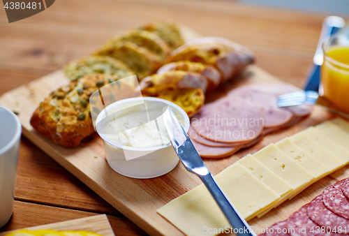 Image of cream cheese and other food on table at breakfast