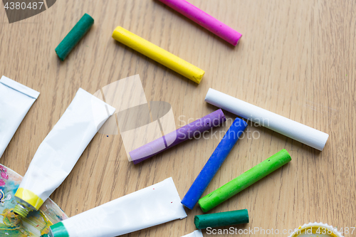 Image of crayons and acrylic color or paint tubes on table