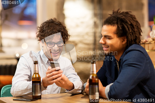 Image of men with smartphone drinking beer at bar or pub