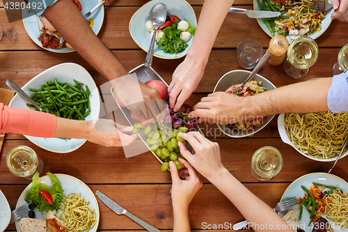 Image of group of people eating at table with food