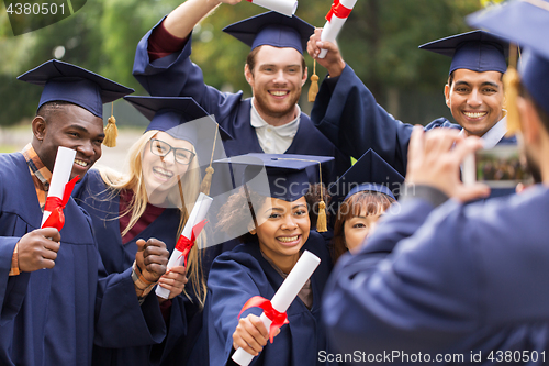 Image of students or graduates with diplomas taking picture