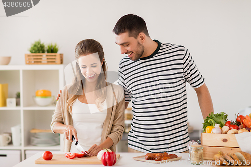 Image of happy couple cooking food at home kitchen