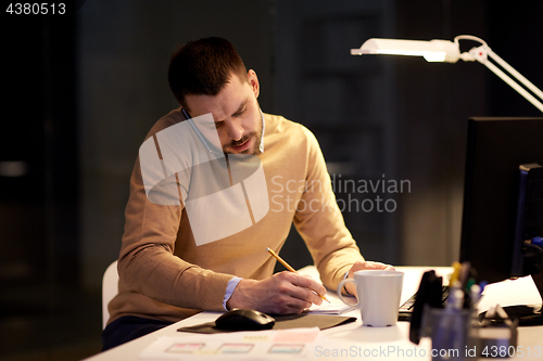 Image of businessman calling on sartphone at night office