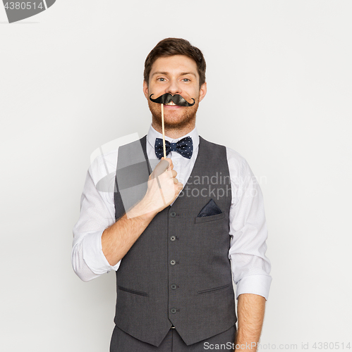 Image of happy young man with fake mustache at party