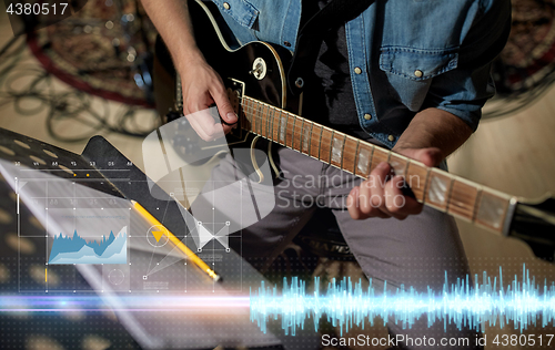 Image of man with music book on stand playing guitar