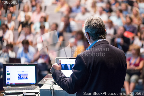 Image of Public speaker giving talk at Business Event.