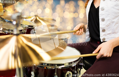 Image of close up of woman drummer playing drum kit