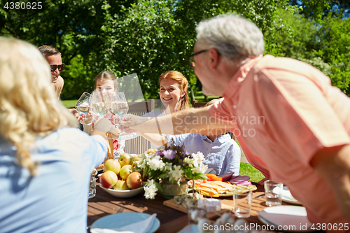 Image of happy family having dinner or summer garden party