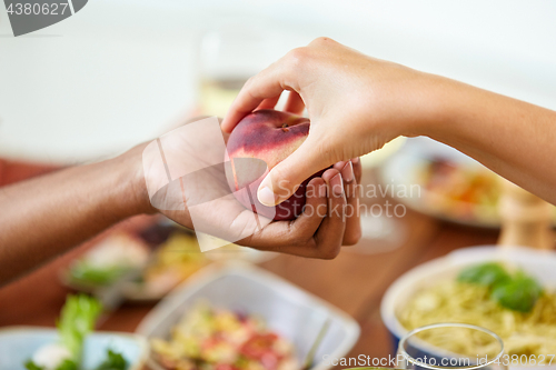 Image of multiracial couple hands with peach