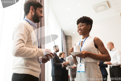 Image of business people with conference badges and coffee