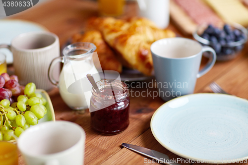 Image of jar with jam on wooden table at breakfast
