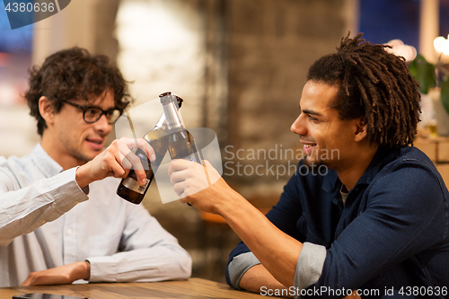 Image of happy male friends drinking beer at bar or pub