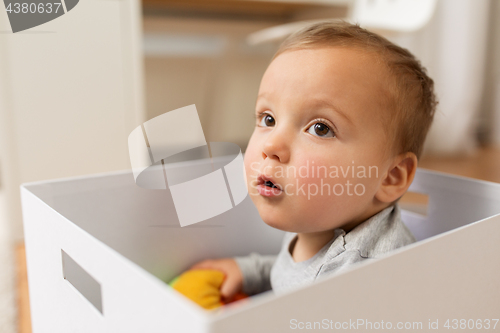 Image of close up of sweet little baby boy in toy box