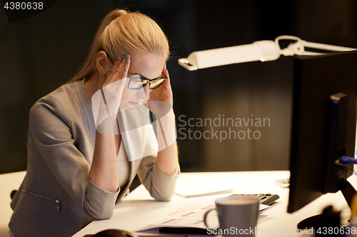 Image of businesswoman at computer working at night office