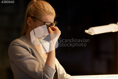 Image of tired businesswoman working at night office