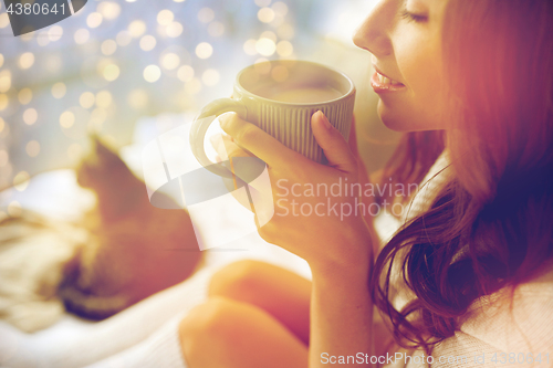 Image of close up of happy woman with cup of cocoa at home