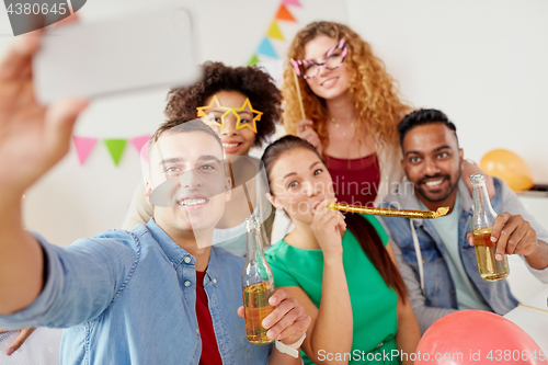 Image of happy team taking selfie at office party